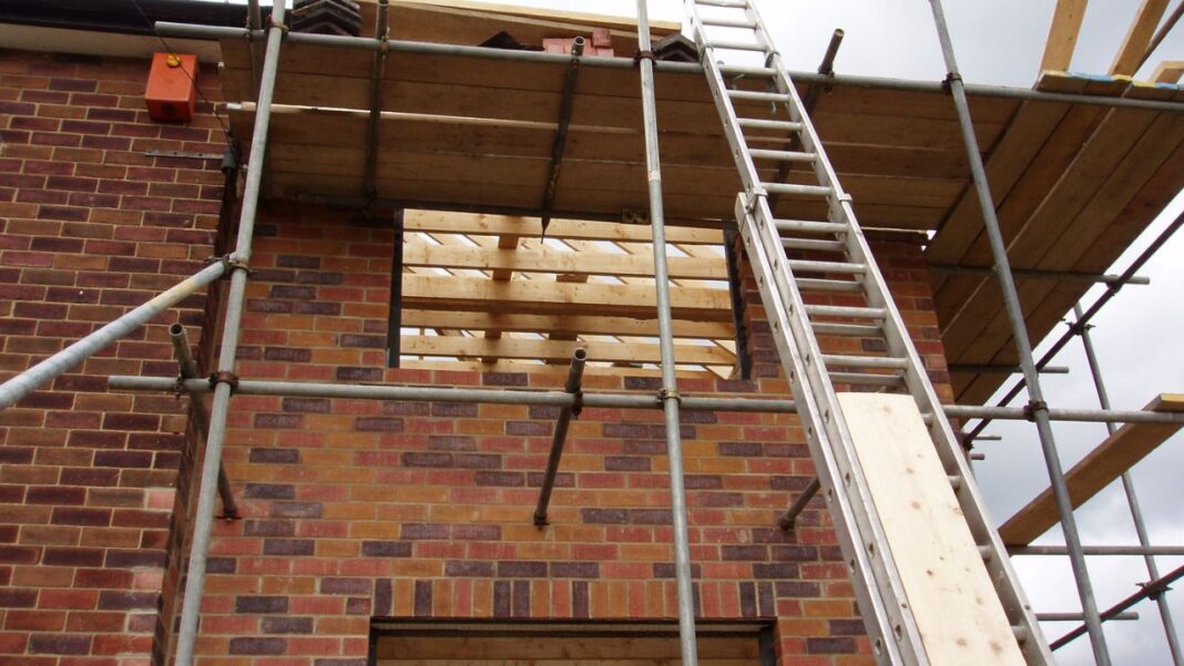 A foldable extension ladder is being used for building the house